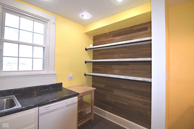 interior space featuring white cabinets, a textured ceiling, and white dishwasher