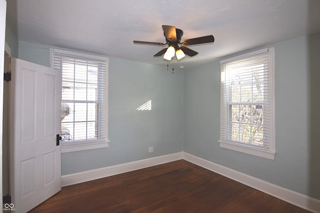 unfurnished room with ceiling fan and dark wood-type flooring