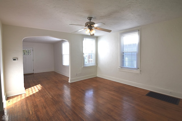 unfurnished room featuring a textured ceiling, ceiling fan, and dark hardwood / wood-style floors