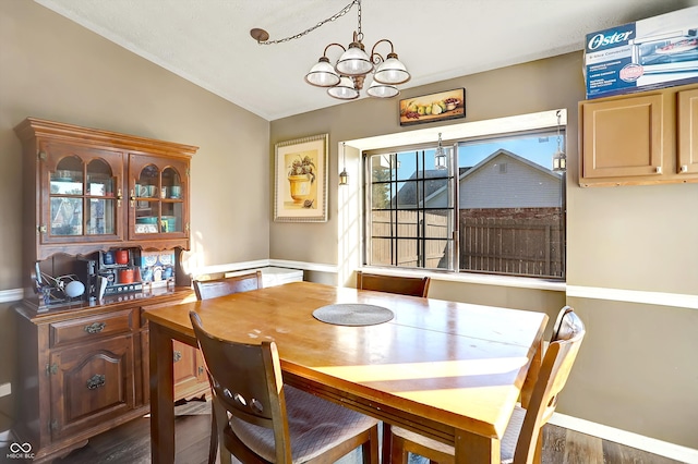 dining space featuring dark wood-type flooring, a chandelier, and lofted ceiling