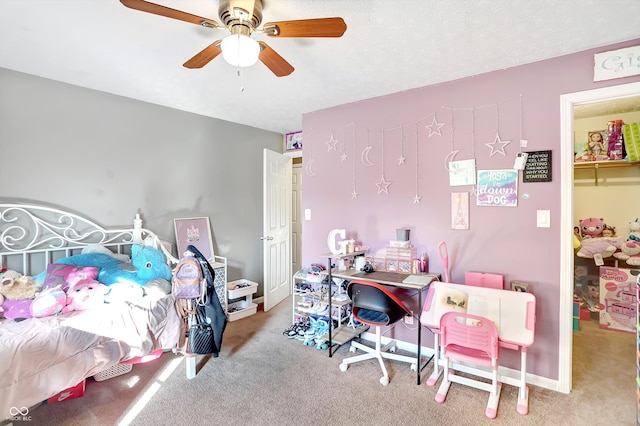 carpeted bedroom with ceiling fan, a closet, and a walk in closet