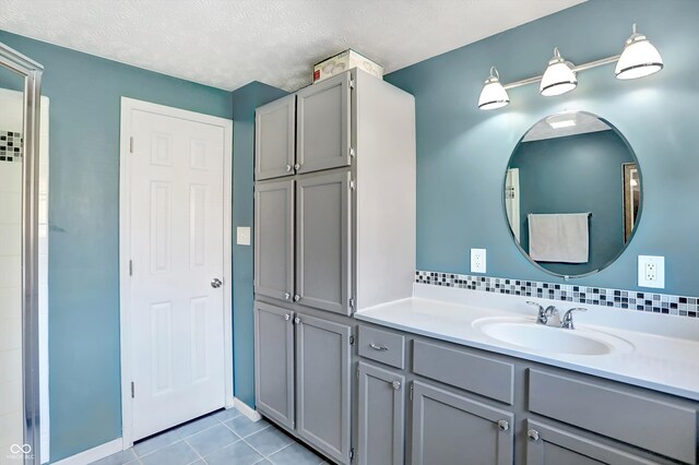 bathroom featuring vanity, a textured ceiling, and tile patterned flooring