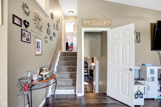 stairway with lofted ceiling and hardwood / wood-style flooring