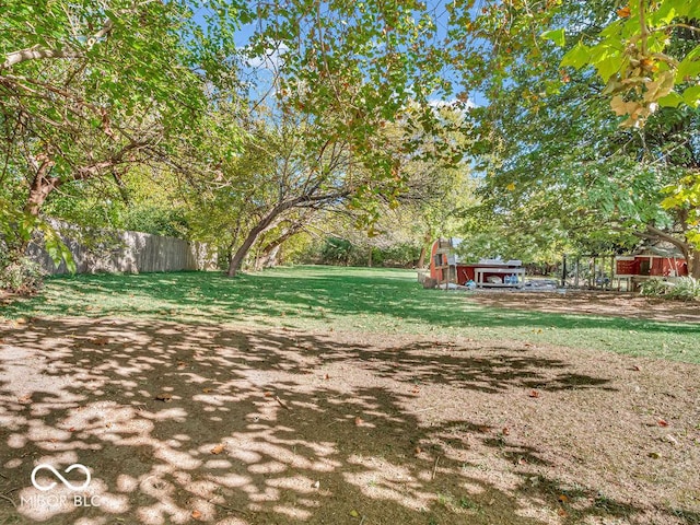 view of yard with an outdoor structure and fence