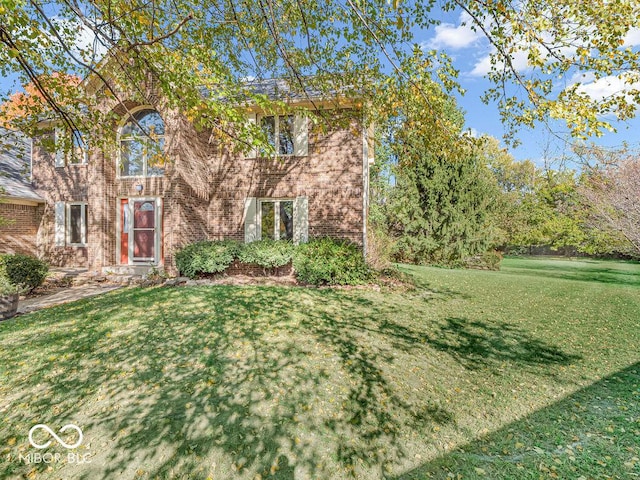 view of front of home with a front lawn and brick siding