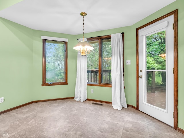 interior space with a chandelier, visible vents, and baseboards
