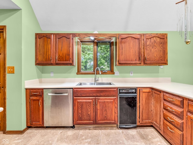 kitchen with vaulted ceiling, stainless steel dishwasher, light countertops, and a sink