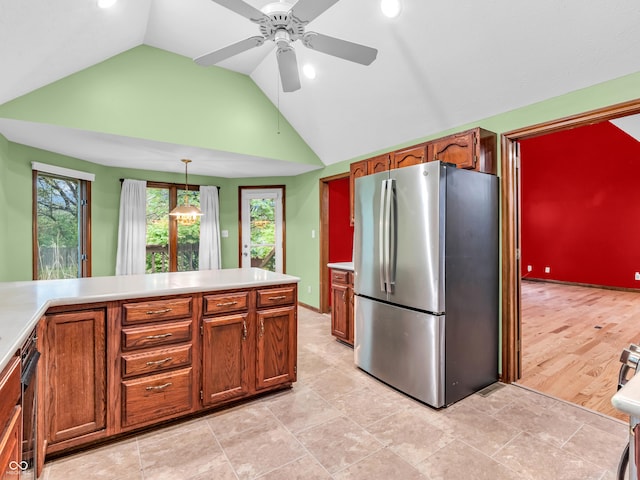 kitchen with freestanding refrigerator, light countertops, vaulted ceiling, brown cabinets, and ceiling fan