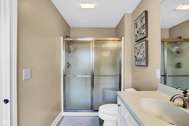 bathroom featuring toilet, a stall shower, and vanity