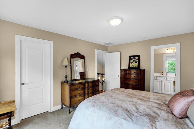 carpeted bedroom featuring visible vents, a sink, baseboards, and ensuite bathroom