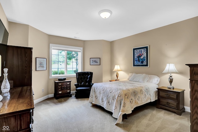 bedroom with light colored carpet and baseboards