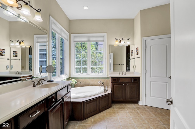 bathroom with a bath, tile patterned flooring, two vanities, and a sink