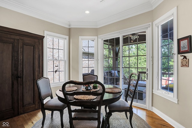 dining area with crown molding, wood-type flooring, and baseboards