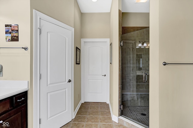 full bath with tile patterned flooring, a shower stall, vanity, and baseboards