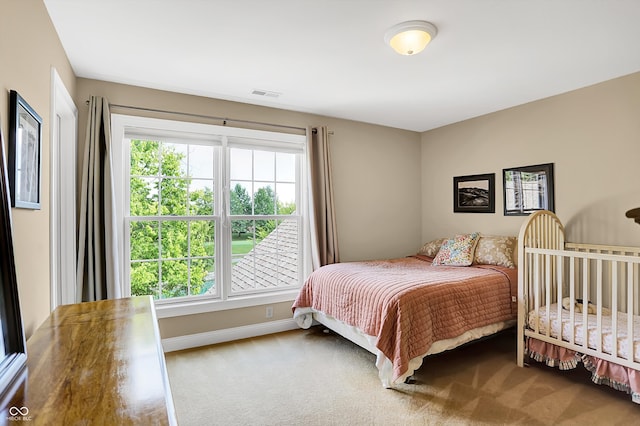 carpeted bedroom featuring visible vents and baseboards