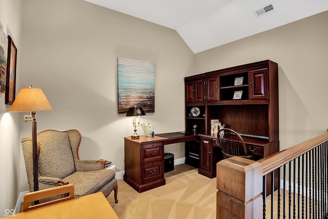 office area with built in desk, visible vents, light carpet, vaulted ceiling, and baseboards