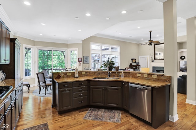 kitchen featuring ornamental molding, appliances with stainless steel finishes, light wood-type flooring, and a sink