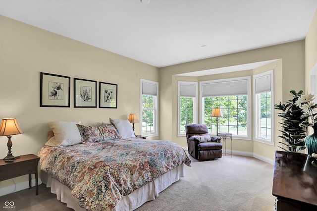 bedroom featuring light colored carpet and baseboards