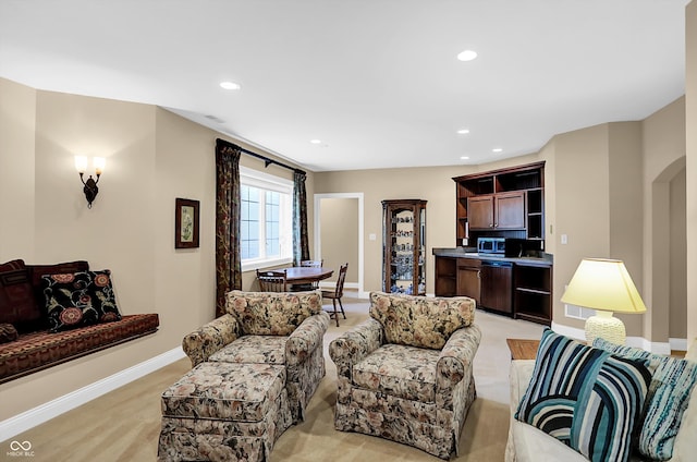 living area featuring arched walkways, baseboards, and recessed lighting