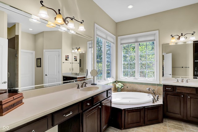 full bath with two vanities, a sink, a bath, and tile patterned floors