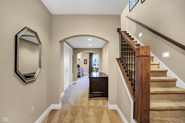 corridor with arched walkways, carpet, baseboards, and recessed lighting