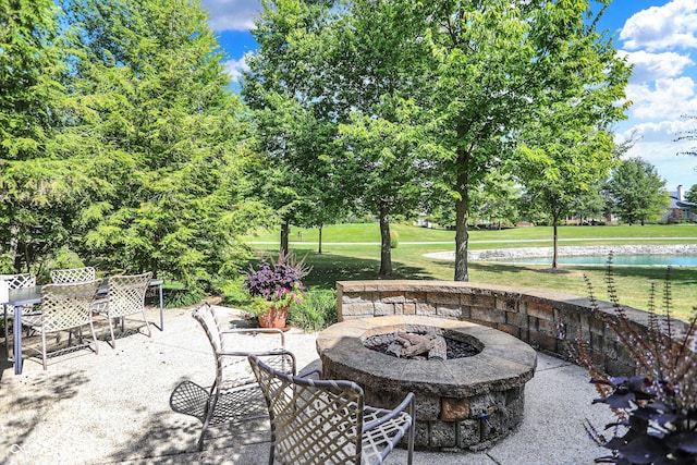 view of patio / terrace featuring an outdoor fire pit, a water view, and outdoor dining space