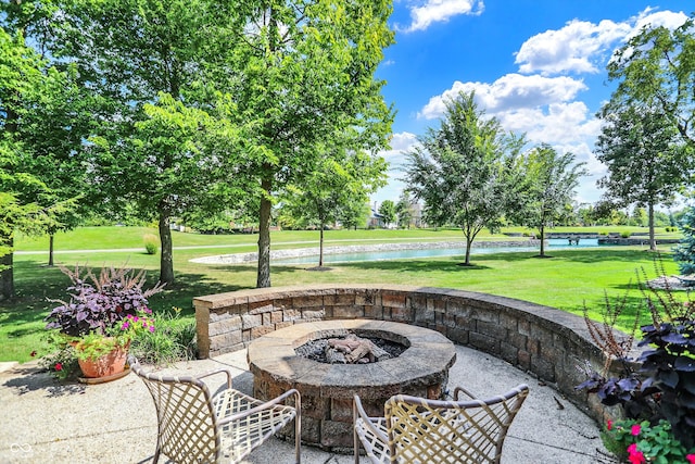 view of patio with an outdoor fire pit and a water view