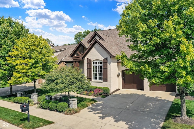 view of front of house featuring a garage, concrete driveway, brick siding, and roof with shingles