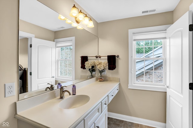 bathroom featuring plenty of natural light, vanity, visible vents, and baseboards