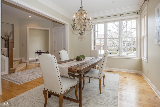 dining room featuring baseboards, light wood finished floors, stairway, and crown molding