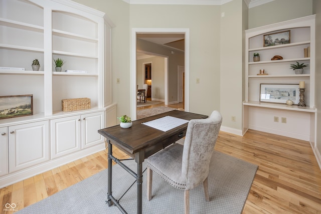 office area with light wood-type flooring, baseboards, and built in features