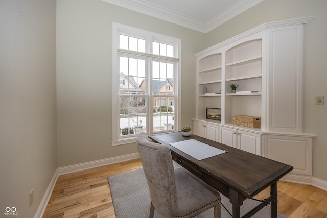 dining room with light wood-style floors, baseboards, and crown molding