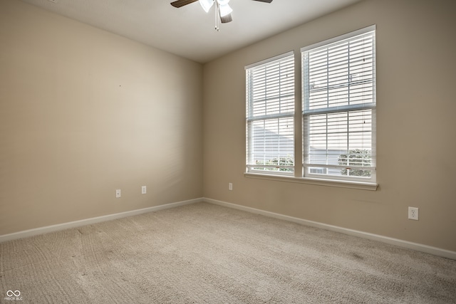 carpeted empty room featuring ceiling fan and a wealth of natural light