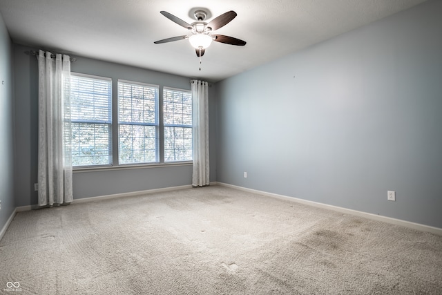 empty room with ceiling fan and carpet flooring