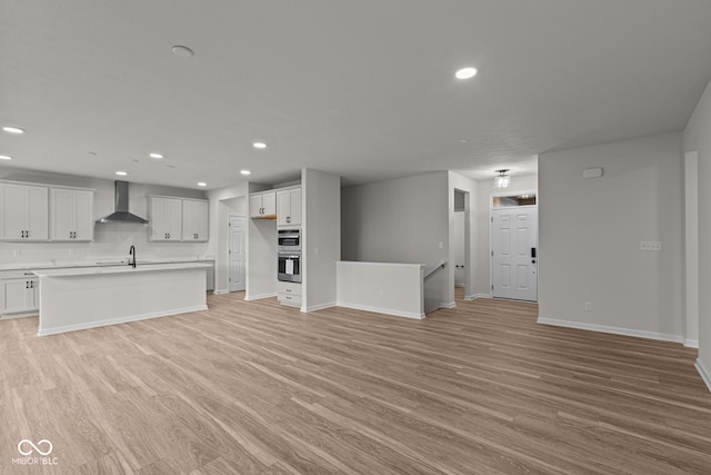 unfurnished living room featuring light wood-type flooring and sink