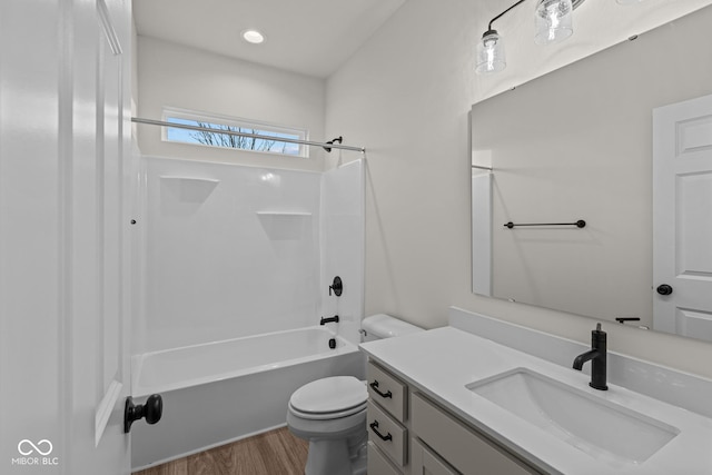 full bathroom featuring hardwood / wood-style floors, vanity,  shower combination, and toilet