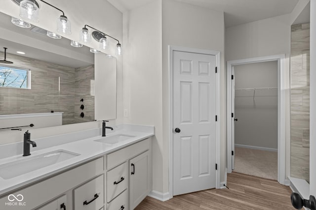 bathroom featuring tiled shower, wood-type flooring, and vanity