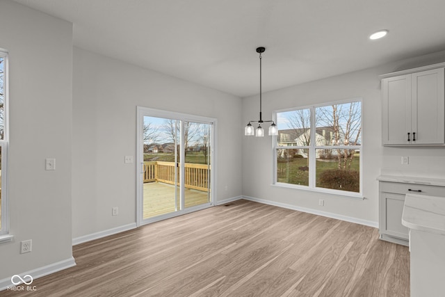 unfurnished dining area featuring a wealth of natural light and light hardwood / wood-style floors