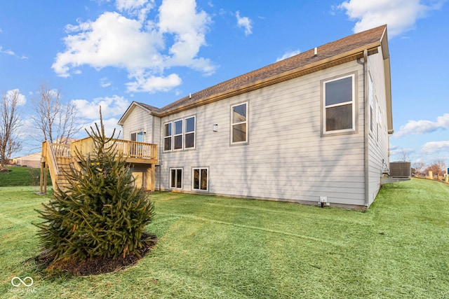 back of property with a yard, a deck, and central AC unit