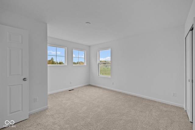 unfurnished bedroom with light carpet and a closet