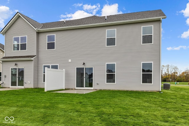 rear view of property with central AC unit, a lawn, and a patio area