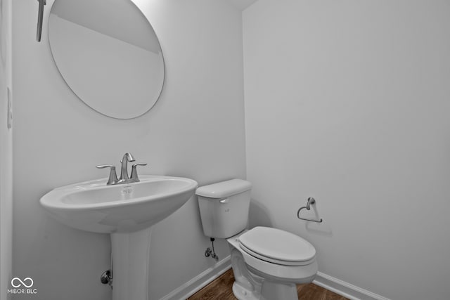 bathroom with hardwood / wood-style flooring and toilet