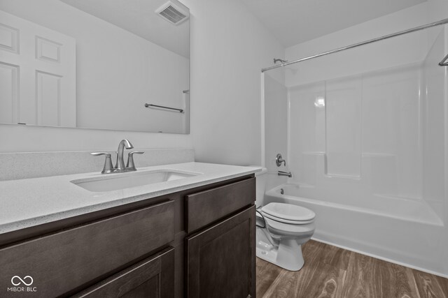 full bathroom featuring toilet, vanity, shower / bathtub combination, and hardwood / wood-style floors