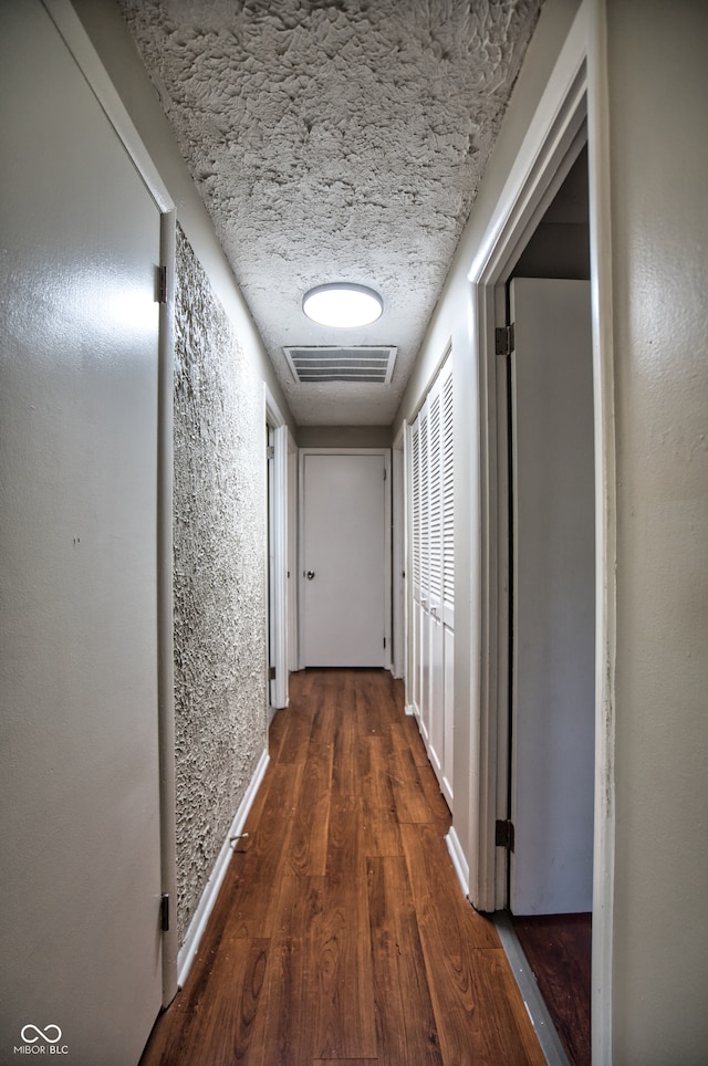 hall featuring dark hardwood / wood-style floors and a textured ceiling