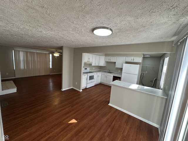 kitchen featuring a wealth of natural light, white appliances, white cabinets, ceiling fan, and dark hardwood / wood-style floors