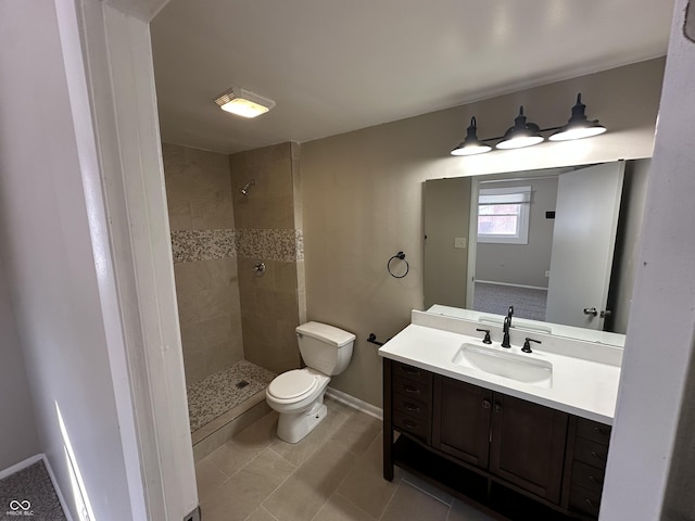 bathroom with tile patterned floors, toilet, vanity, and a tile shower