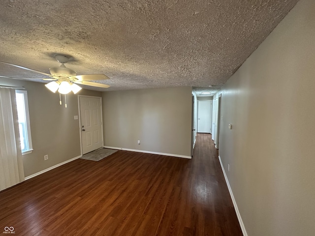 empty room featuring ceiling fan, dark hardwood / wood-style floors, and a textured ceiling