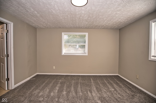 carpeted spare room with a textured ceiling