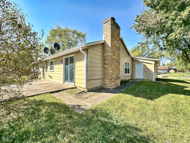 rear view of property featuring a lawn