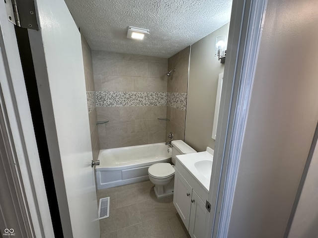 full bathroom with tiled shower / bath combo, toilet, a textured ceiling, and vanity